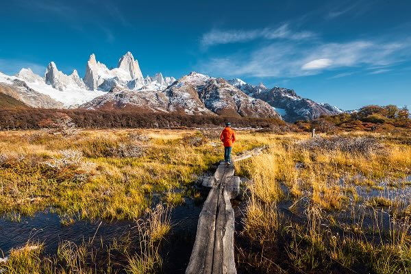 A person hiking in front of a mountain